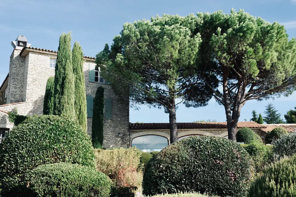 Maison en pierre et cyprès baignés par la lumière de Provence