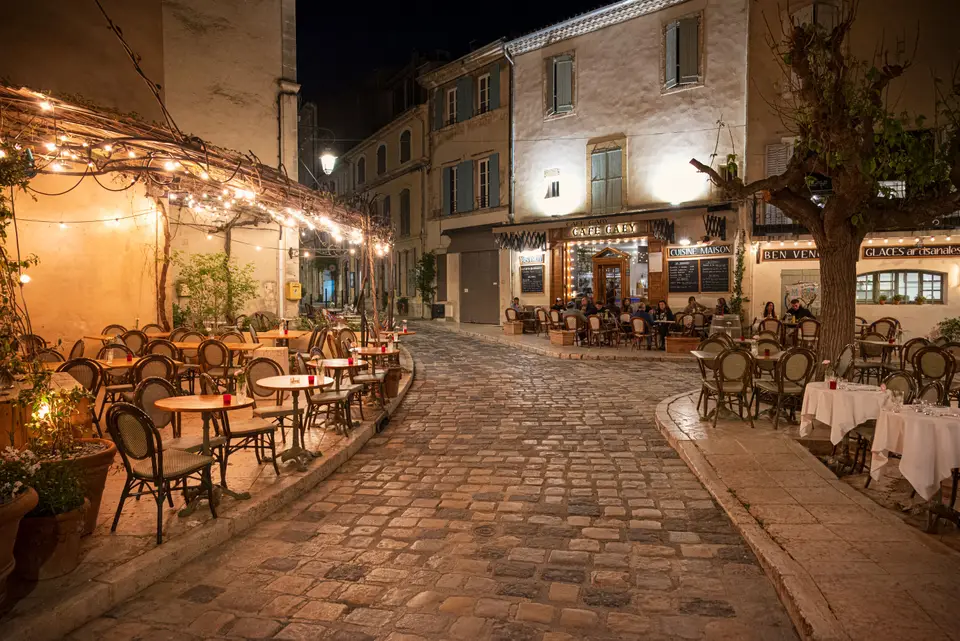 Terrasses animées dans un village provençal en soirée
